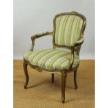 A Louis XV style carved gilt wood fauteuil, c1900, with green striped upholstery, on scroll legs,