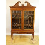 An Edwardian inlaid display cabinet, with astragal glazed doors below a swan neck pediment,