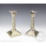 A pair of silver plated Corinthian column candlesticks with acanuthus detail,