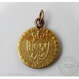 A George III gold spade Guinea coin dated indistinctly 1794, shield back, soldered pendant mount,