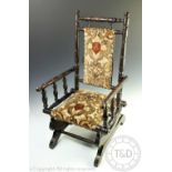 A 19th century childs stained beech American style rocking chair, upholstered,