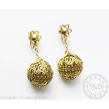 An unusual pair of Indian silver gilt earrings, designed as a hinged, filligree sphere,