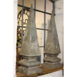 A large pair of carved marble obelisks, each of tapered form on stepped and cushioned square bases,