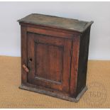 A 19th century oak spice cabinet with panelled door enclosing two shelves,
