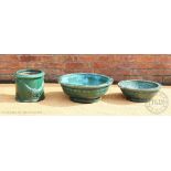 Two Chinese green glazed circular garden planters, 63cm diam and 50cm diam,