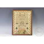 An early 19th century needlework sampler, worked with a country house and animals on the lawn,