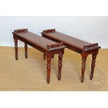 A pair of Victrorian style walnut window seats, with scroll ends, on turned legs,