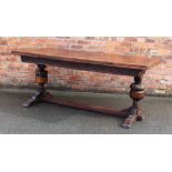 A 17th century style carved oak extending refectory type table, two tow leaves, on baluster legs,