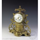 A late 19th century French brass mantle clock, Roman numeral dial with movement striking on a gong,