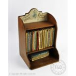 An early 20th century 'Peter Rabbits Book Shelf', the oak shelf with original label,