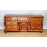 A late Victorian pine dresser base, with an arrangement of seven drawers,