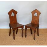 A pair of Victorian pitch pine hall chairs, with solid seats on turned legs,