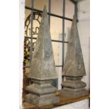 A large pair of carved marble obelisks, each of tapering form on stepped and cushioned square bases,