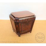 A Regency mahogany cellarette, of sarcophagus form, with hinged lid enclosing a divided interior,