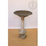 A reconstituted stone garden bird bath, with circular top,