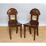 A pair of Victorian carved oak hall chairs, each back inset with a John Moyr Smith for Minton tile,