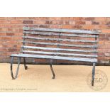 A late Victorian wrought iron slatted garden bench, with scroll supports, 88cm H x 153cm W,