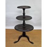 A Victorian carved mahogany three tier dumb waiter, with floral detailing, on tripod base,