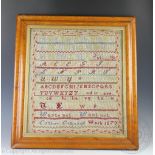 A Victorian needlework sampler by Esther Evans dated 1870, worked with alphabets and small verse,