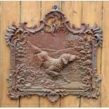 A cast iron fireback, decorated with a dog 57cm x 55cm, with two sheep door stops, an iron,