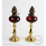 A pair of Victorian oil lamps, each cranberry glass reservoir 'Sales Safety Burner' 'RdNo.