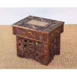 An early 20th century Chinese carved folding occasional table, decorated with dragons and symbols,