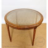 A French style stained beech hall or centre table, the circular top carved with a glass insert,