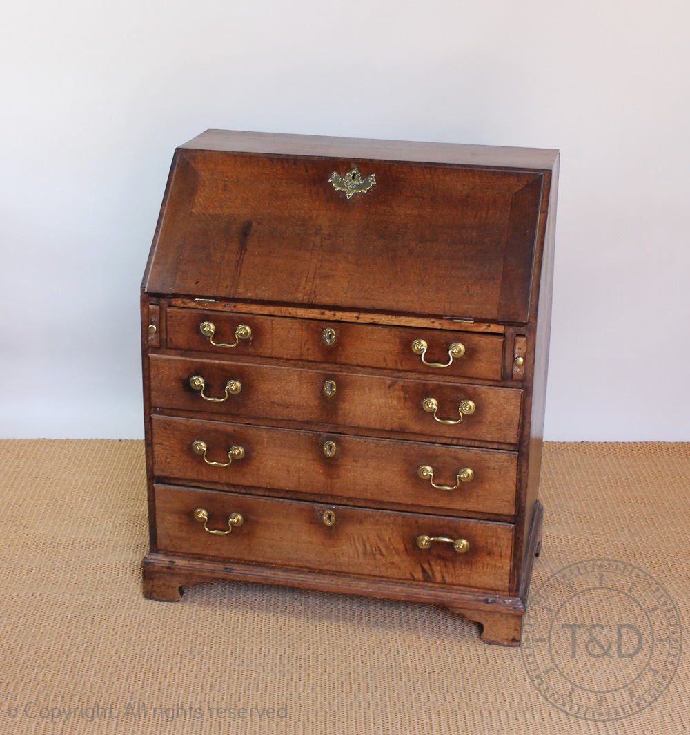 A George III oak bureau, with fall enclosing a fitted interior, above four graduated long drawers,