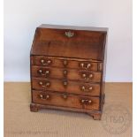 A George III oak bureau, with fall enclosing a fitted interior, above four graduated long drawers,