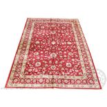 A Kashmir carpet, worked with an all over floral design against a red ground,