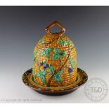 A majolica cheese bell and base, modelled as a bee hive with fruiting vines, stamped 'MINTON',