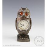 An early 20th century spelter novelty owl time piece, with Arabic dial and amber coloured eyes, 16.