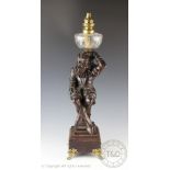 A large Black Forest type carved figural oil lamp,