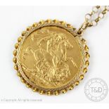 A George V gold sovereign dated 1917, within a gold surround and attached 9ct gold chain,