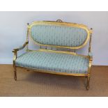 A carved and giltwood Louis XVI style canape, early 20th century, with foliate blue upholstery,