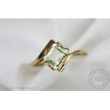 A citrine set ring, of cross-over design and set with a central emerald cut stone,