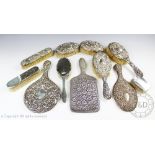 An assortment of ten late Victorian and later silver back hand mirrors and brushes,