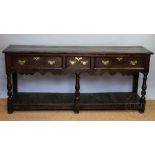 An 18th century type oak dresser, with an arrangement of three drawers, above a pot shelf,