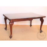 An Edwardian mahogany extending dining table, with one spare leaf, on cabriole legs and pad feet,