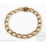 A yellow metal flattened curb link bracelet with integral clasp and double safety catch,