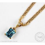 A topaz and diamond pendant in yellow metal setting stamped '9ct',