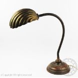 An early 20th century plated articulated desk lamp, with brass shell shade, on circular copper base,