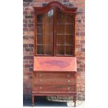 An Edwardian inlaid mahogany bureau bookcase, with serpentine top over two glazed doors,