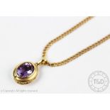 An amethyst pendant in 14k gold setting and attached 9ct gold chain,