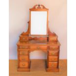 An Edwardian walnut dressing table, with swing mirror above nine drawers, on plinth base,