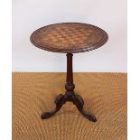 A Victorian inlaid walnut games table, with circular top, on carved tripod base,