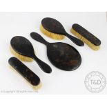 An Art Deco five piece tortoiseshell dressing table set comprising; a hand mirror,