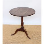 A George III circular oak occasional table, with three plank top, on tripod base,