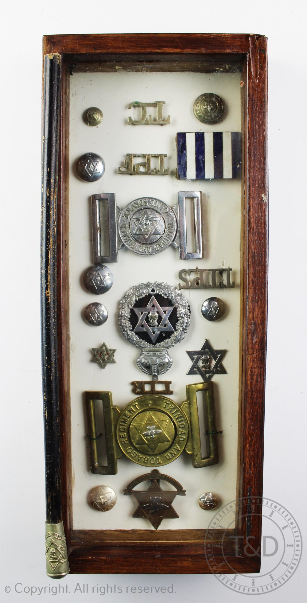 A collection of Trinidad and Tobago police uniform buckles, badges, initials and stars,