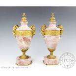 A pair of ormolu mounted veined pink marble urns in the manner of Matthew Boulton,